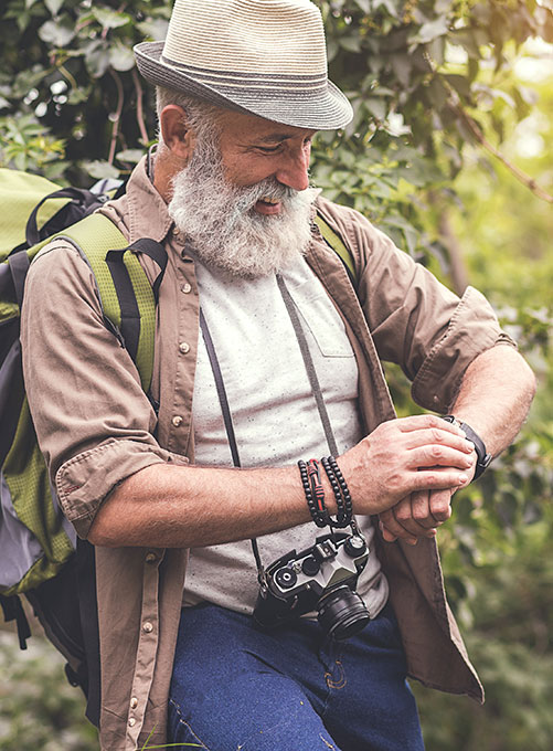 Image showing a strong man in the wild smiling and watching at his watch.
